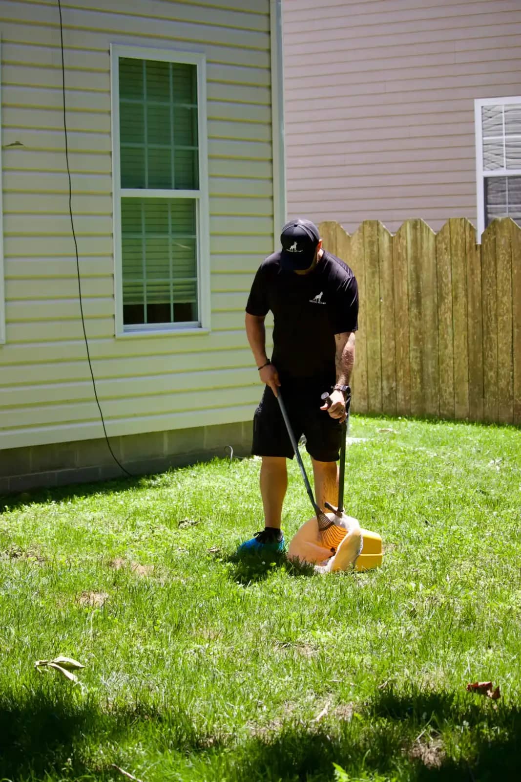 Doggy Scoop backyard pet waste removal Doggy Scoop technician cleaning pet waste from a fenced backyard